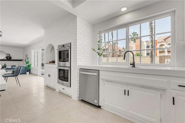 9921 Oceancrest Dr, Huntington Beach, CA 92646 - kitchen featuring stainless steel appliances, light tile patterned floors, light countertops, and white cabinetry