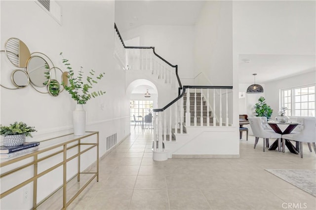 9921 Oceancrest Dr, Huntington Beach, CA 92646 - entryway featuring a towering ceiling, stairway, tile patterned flooring, and arched walkways