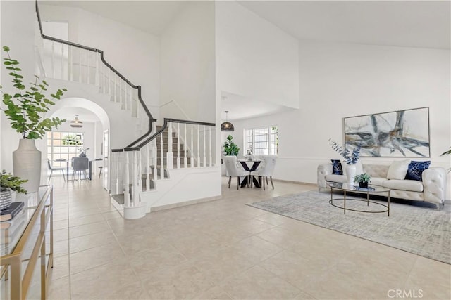 9921 Oceancrest Dr, Huntington Beach, CA 92646 - living area with a high ceiling, stairway, arched walkways, and tile patterned floors