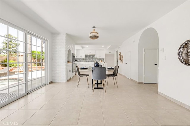 9921 Oceancrest Dr, Huntington Beach, CA 92646 - dining space featuring light tile patterned flooring and arched walkways