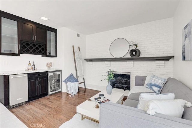 9921 Oceancrest Dr, Huntington Beach, CA 92646 - living room with beverage cooler, bar, a fireplace, and light wood-style floors