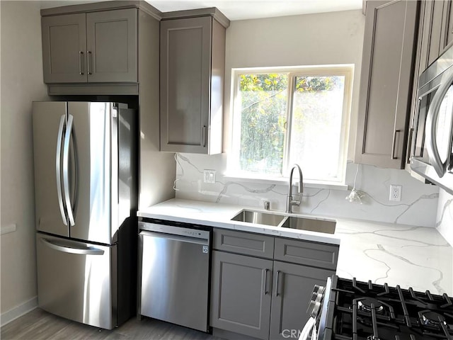 5126 Colfax Ave, Valley Village, CA 91601 - kitchen featuring stainless steel appliances, gray cabinets, decorative backsplash, light stone counters, and light wood-style floors