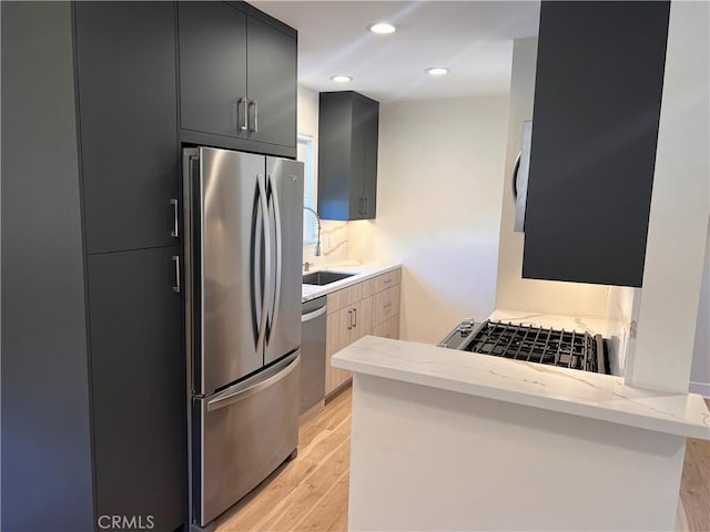 5126 Colfax Ave, Valley Village, CA 91601 - kitchen featuring appliances with stainless steel finishes, light wood-style floors, a peninsula, dark cabinetry, and recessed lighting