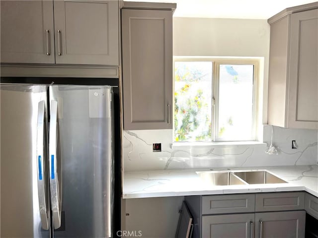 5126 Colfax Ave, Valley Village, CA 91601 - kitchen featuring freestanding refrigerator, gray cabinetry, backsplash, and light stone counters