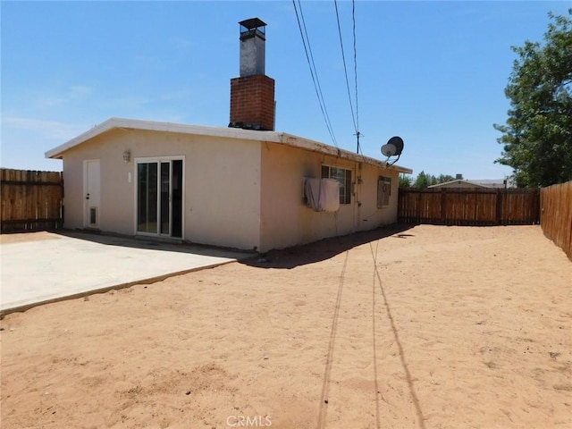 14200 Pawnee Rd, Apple Valley, CA 92307 - rear view of property with a patio area, a fenced backyard, stucco siding, and a chimney