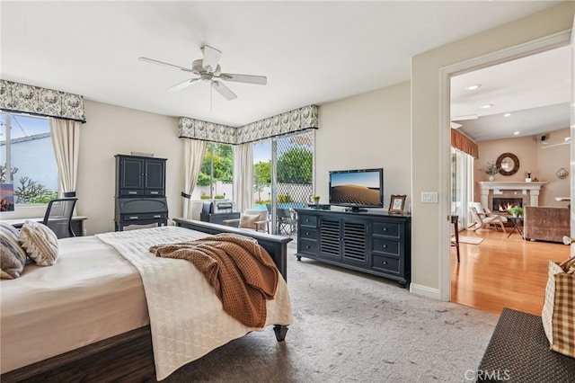 11272 Weatherby Rd, Los Alamitos, CA 90720 - carpeted bedroom featuring multiple windows, access to outside, recessed lighting, a glass covered fireplace, and a ceiling fan