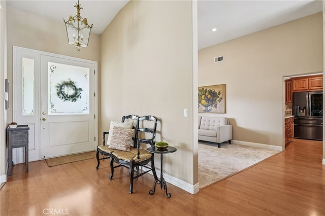 11272 Weatherby Rd, Los Alamitos, CA 90720 - entryway with light wood finished floors, a chandelier, a towering ceiling, and recessed lighting