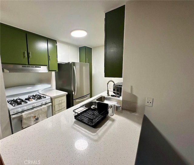 8601 International Ave Unit 271, Canoga Park, CA 91304 - kitchen featuring green cabinetry, under cabinet range hood, freestanding refrigerator, white range with gas cooktop, and light countertops