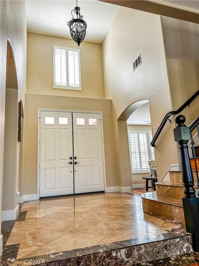 14207 Ashton Ln, Riverside, CA 92508 - entrance foyer featuring a high ceiling, arched walkways, marble tiled flooring, a chandelier, and stairs