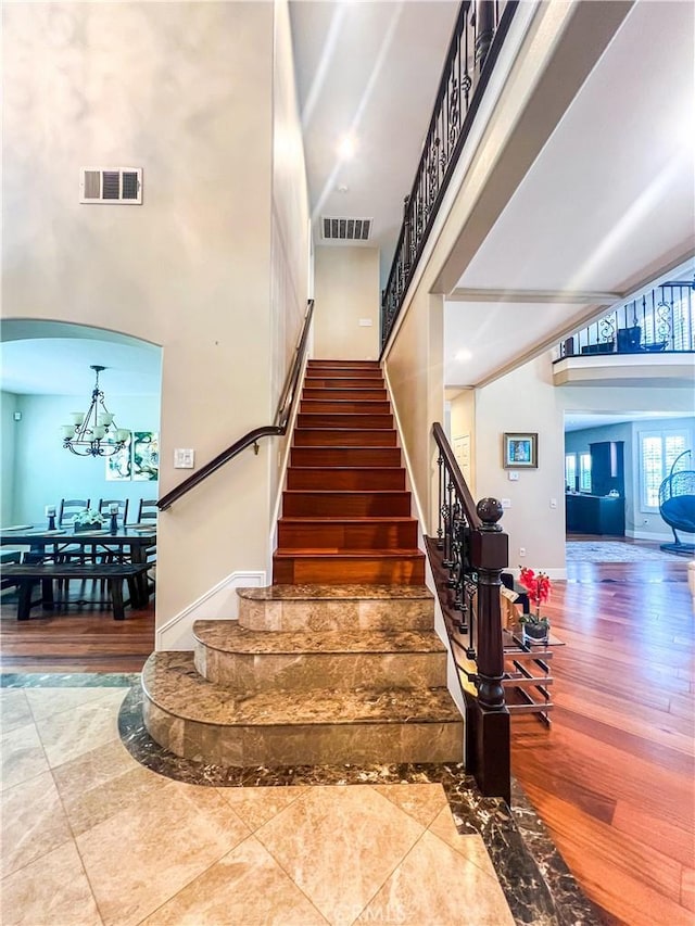 14207 Ashton Ln, Riverside, CA 92508 - stairs with a high ceiling, a chandelier, arched walkways, and wood finished floors