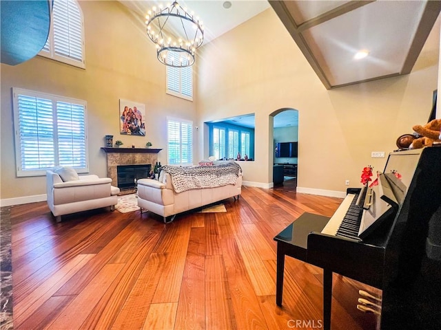14207 Ashton Ln, Riverside, CA 92508 - living room featuring hardwood / wood-style flooring, arched walkways, a fireplace, a chandelier, and healthy amount of natural light