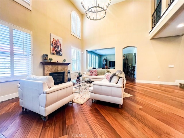 14207 Ashton Ln, Riverside, CA 92508 - living room with arched walkways, healthy amount of natural light, a tile fireplace, a chandelier, and a high ceiling