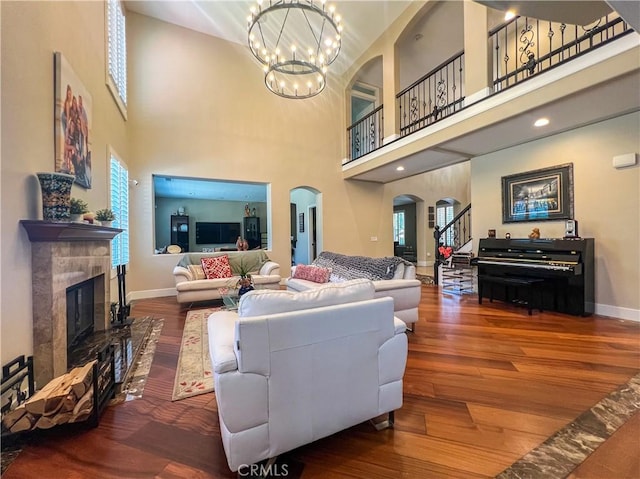 14207 Ashton Ln, Riverside, CA 92508 - living area featuring arched walkways, a high ceiling, a chandelier, a fireplace, and wood finished floors