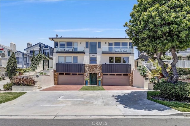 34586 Camino Capistrano Unit B, Dana Point, CA 92624 - townhome / multi-family property featuring stone siding, stucco siding, driveway, and a garage