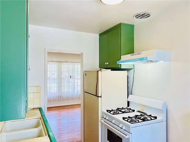 122 Elm Ave Unit 10, Long Beach, CA 90802 - kitchen with white range with gas cooktop, green cabinets, under cabinet range hood, light wood-type flooring, and light countertops
