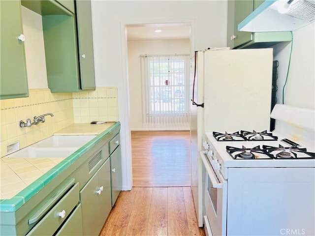 122 Elm Ave Unit 10, Long Beach, CA 90802 - kitchen featuring gas range gas stove, green cabinetry, under cabinet range hood, and light wood-type flooring