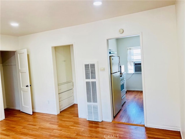 122 Elm Ave Unit 10, Long Beach, CA 90802 - interior space featuring a heating unit, freestanding refrigerator, light wood-type flooring, and recessed lighting