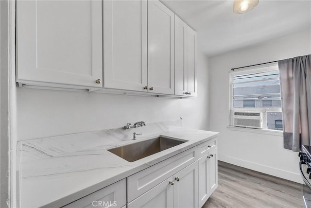 122 Elm Ave Unit 11, Long Beach, CA 90802 - kitchen with white cabinetry, light stone counters, light wood-style floors, and cooling unit