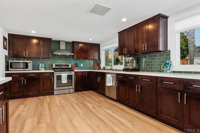 2203 Cameo Rd, Carlsbad, CA 92008 - kitchen featuring appliances with stainless steel finishes, wall chimney range hood, light countertops, healthy amount of natural light, and recessed lighting