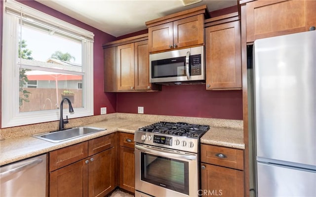7441 Sylvia Ave, Reseda, CA 91335 - kitchen with stainless steel appliances, light countertops, and brown cabinets