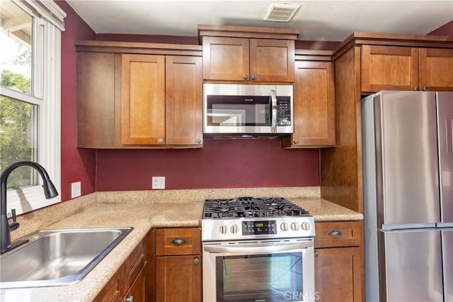 7441 Sylvia Ave, Reseda, CA 91335 - kitchen featuring appliances with stainless steel finishes, brown cabinets, and light countertops