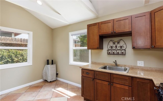 7441 Sylvia Ave, Reseda, CA 91335 - kitchen featuring vaulted ceiling, brown cabinetry, light tile patterned floors, and stove