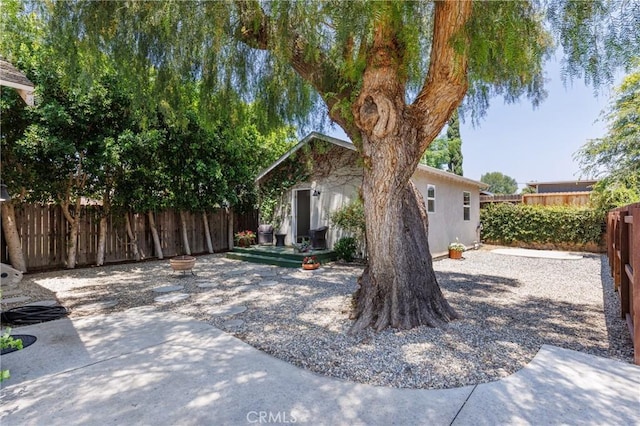 7441 Sylvia Ave, Reseda, CA 91335 - view of front of property with a fenced backyard, stucco siding, a patio, and an outdoor structure