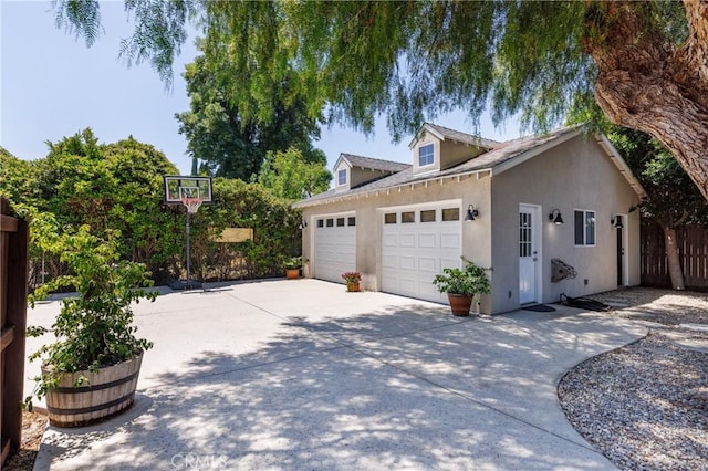 7441 Sylvia Ave, Reseda, CA 91335 - view of side of property featuring concrete driveway, an attached garage, and stucco siding