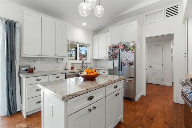 4835 Almidor Ave, Woodland Hills, CA 91364 - kitchen featuring stainless steel appliances, lofted ceiling, wood finished floors, decorative backsplash, and white cabinetry