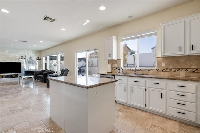 13238 Dancy St, Eastvale, CA 92880 - kitchen featuring stone countertops, healthy amount of natural light, white cabinets, backsplash, and recessed lighting