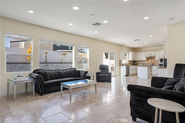 13238 Dancy St, Eastvale, CA 92880 - living room featuring healthy amount of natural light, recessed lighting, and stone tile flooring