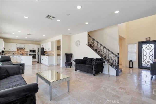 13238 Dancy St, Eastvale, CA 92880 - living area featuring recessed lighting, stairway, and stone tile flooring