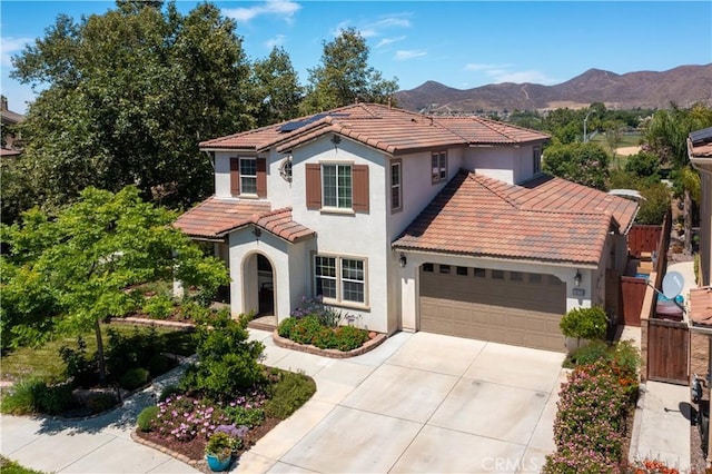 28233 Millstream Ct, Menifee, CA 92585 - mediterranean / spanish home with a tiled roof, a garage, concrete driveway, stucco siding, and roof mounted solar panels