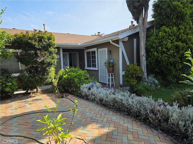 15901 Lassen St, North Hills, CA 91343 - view of side of property featuring stucco siding, a patio area, and a chimney