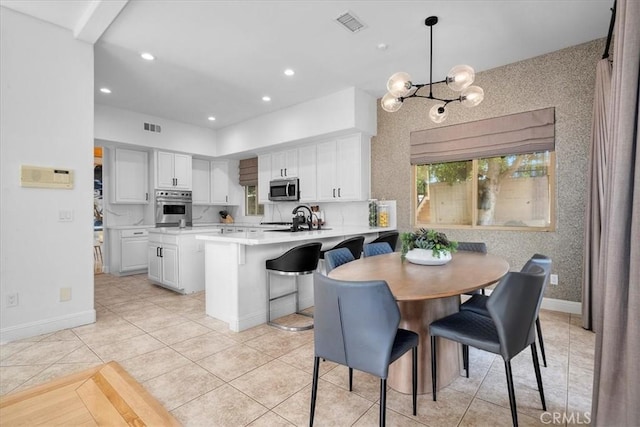 18330 Hanan Ct, Tarzana, CA 91356 - kitchen featuring stainless steel appliances, light countertops, white cabinets, a chandelier, and a peninsula