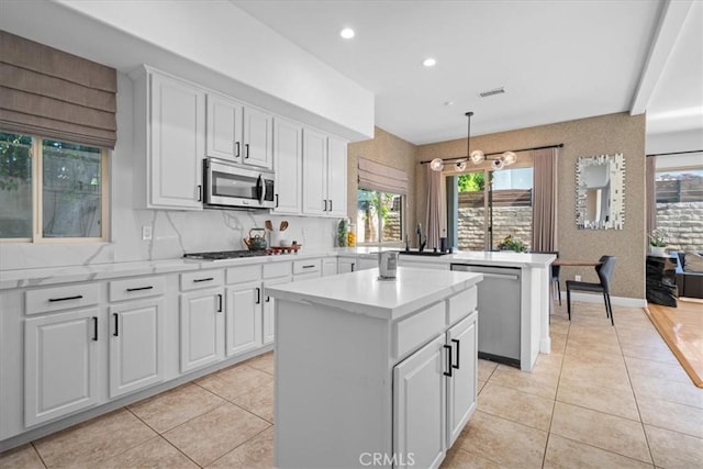18330 Hanan Ct, Tarzana, CA 91356 - kitchen with stainless steel appliances, a kitchen island, light tile patterned flooring, white cabinets, and recessed lighting