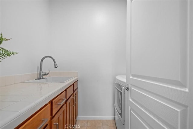 18330 Hanan Ct, Tarzana, CA 91356 - washroom featuring washer and dryer, cabinet space, and light tile patterned flooring