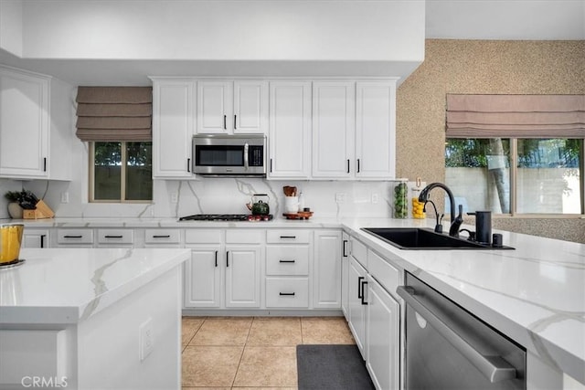 18330 Hanan Ct, Tarzana, CA 91356 - kitchen with appliances with stainless steel finishes, light tile patterned floors, white cabinets, light stone countertops, and backsplash