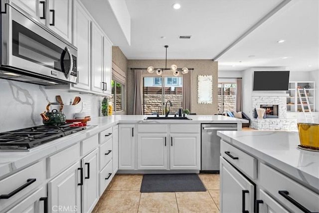 18330 Hanan Ct, Tarzana, CA 91356 - kitchen featuring stainless steel appliances, light countertops, tasteful backsplash, white cabinets, and light tile patterned floors
