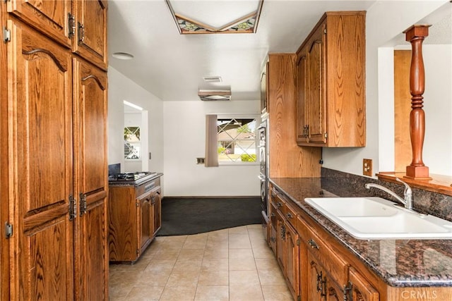 625 S Valley St, Anaheim, CA 92804 - kitchen featuring light carpet, brown cabinetry, dark stone countertops, and light tile patterned flooring
