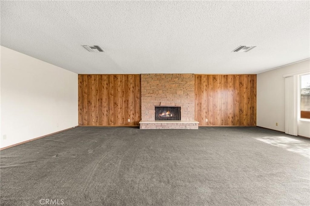 625 S Valley St, Anaheim, CA 92804 - unfurnished living room with wood walls, a textured ceiling, dark carpet, and a fireplace