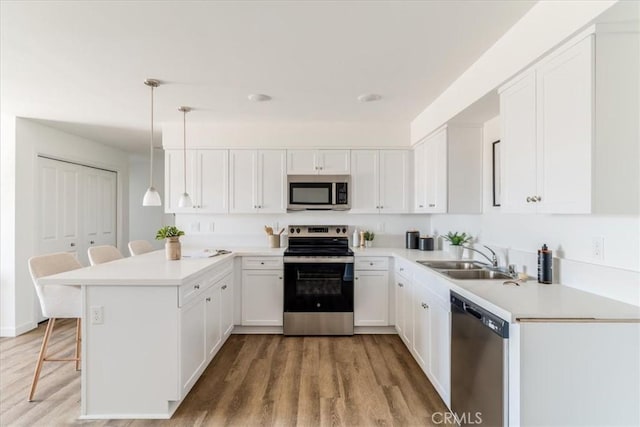3802 Ranch House Rd Unit 102, San Luis Obispo, CA 93401 - kitchen with appliances with stainless steel finishes, a peninsula, light wood finished floors, and a breakfast bar