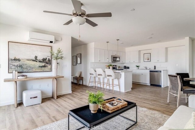 3802 Ranch House Rd Unit 102, San Luis Obispo, CA 93401 - living area with a wall unit AC, light wood-style flooring, and ceiling fan