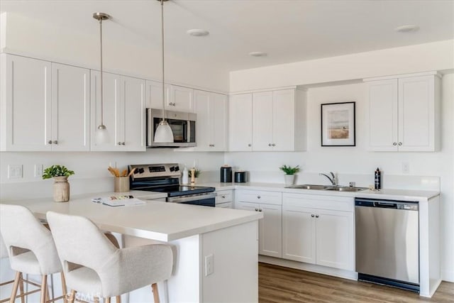 3802 Ranch House Rd Unit 102, San Luis Obispo, CA 93401 - kitchen featuring stainless steel appliances, a peninsula, a breakfast bar area, white cabinets, and wood finished floors