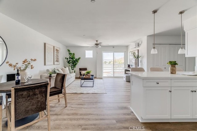 3802 Ranch House Rd Unit 102, San Luis Obispo, CA 93401 - kitchen with light wood-style flooring, a ceiling fan, light countertops, white cabinets, and pendant lighting