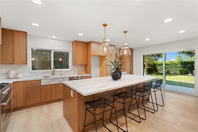 20371 Allport Ln, Huntington Beach, CA 92646 - kitchen with stainless steel appliances, light wood-style floors, backsplash, light stone countertops, and a kitchen island