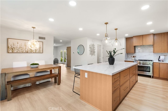 20371 Allport Ln, Huntington Beach, CA 92646 - kitchen with stainless steel stove, recessed lighting, light wood finished floors, backsplash, and a kitchen island