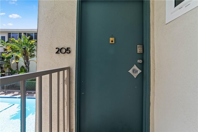 1525 N Hayworth Ave Unit 205, Los Angeles, CA 90046 - property entrance featuring stucco siding and a community pool
