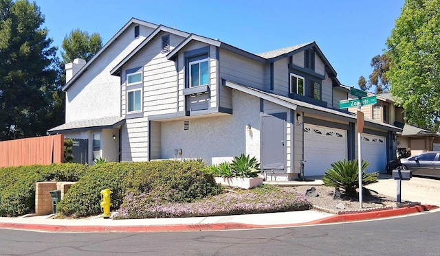 5312 Caminito Cachorro, San Diego, CA 92105 - view of front of house with stucco siding, an attached garage, concrete driveway, and a chimney
