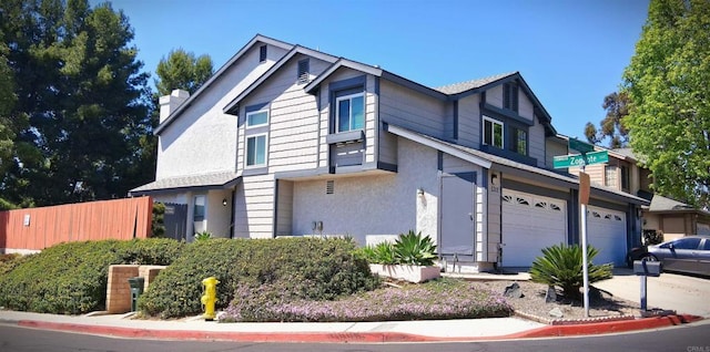 5312 Caminito Cachorro, San Diego, CA 92105 - view of front facade with stucco siding, an attached garage, driveway, and a chimney